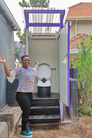 Happy woman customer standing in front of her home toilet structure